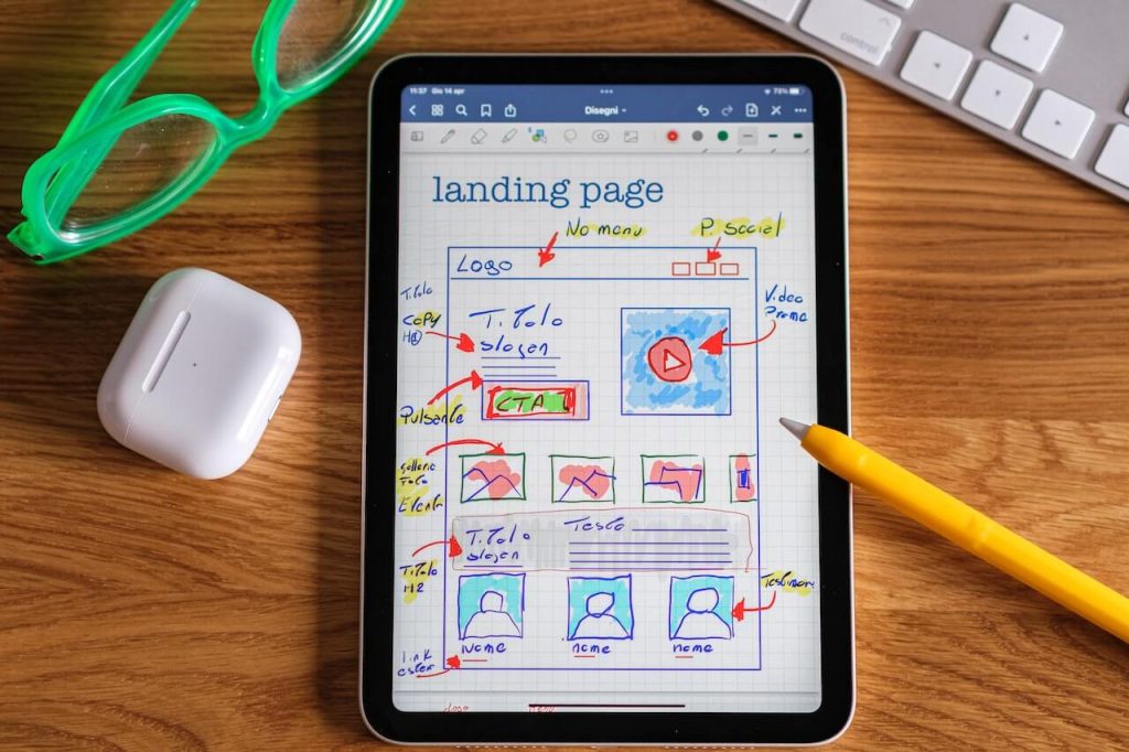 Ein Bild mit einem Tablet, das eine digitale Zeichnung eines neuen Website-Layouts zeigt.